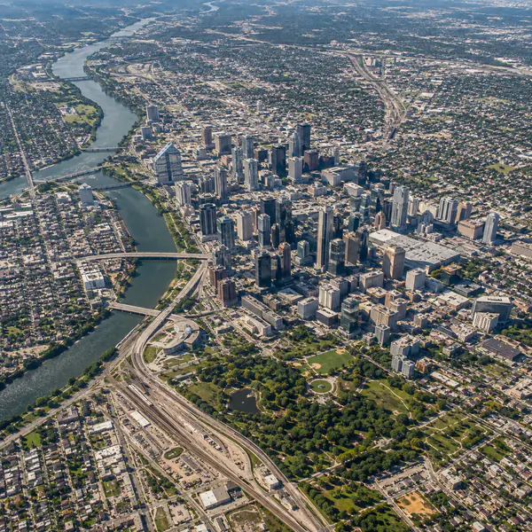 Aerial City View — Looks down from a high viewpoint to reveal the street network, blocks, districts, and wider geography