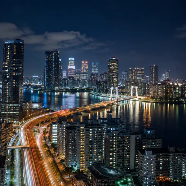 Night Cityscape — Uses illuminated buildings, traffic, signs, and reflections to describe urban life after dark